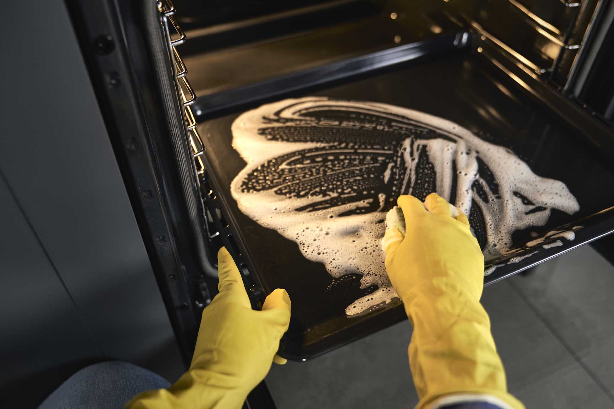 Close up of caucasian woman cleaning oven at home