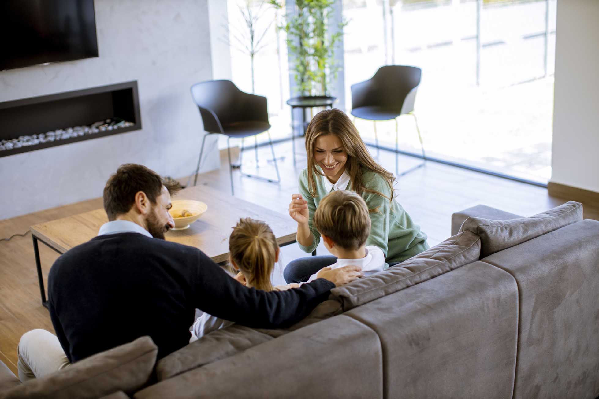 Young family watching TV together on the sofa in the living room